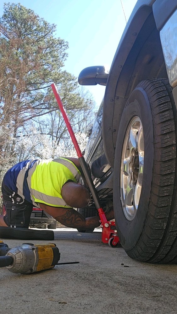 Technician assisting a stranded vehicle on the roadside